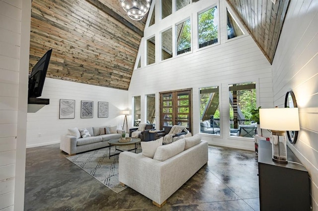 316 Triton Trl, Broken Bow, OK 74728 - living room featuring high vaulted ceiling, concrete floors, wooden walls, french doors, and a chandelier
