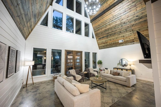 316 Triton Trl, Broken Bow, OK 74728 - living room featuring finished concrete flooring, high vaulted ceiling, wooden walls, and a chandelier