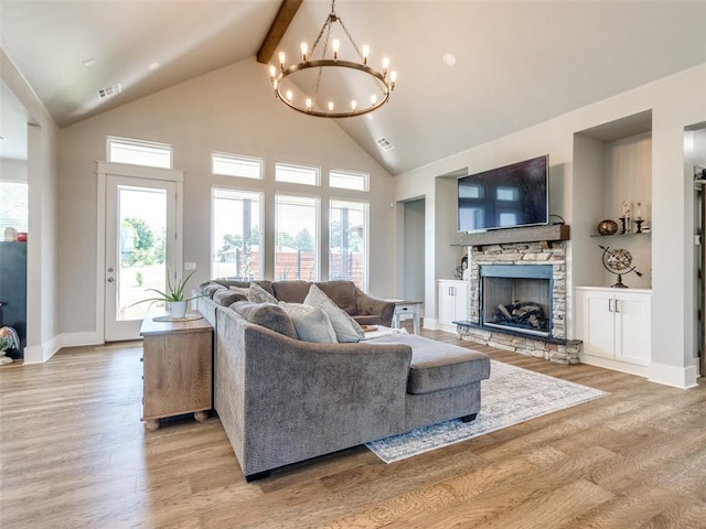22795 Cterling Dr, Kingfisher, OK 73750 - living area with a chandelier, light wood finished floors, high vaulted ceiling, a stone fireplace, and beam ceiling