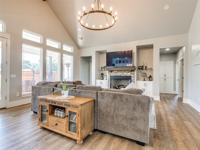 22795 Cterling Dr, Kingfisher, OK 73750 - living area featuring a chandelier, light wood-style floors, a stone fireplace, and high vaulted ceiling
