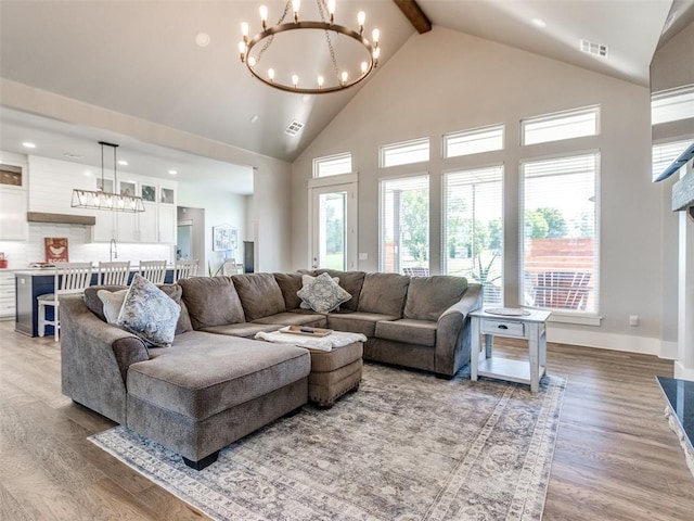 22795 Cterling Dr, Kingfisher, OK 73750 - living area with a chandelier, high vaulted ceiling, wood finished floors, beam ceiling, and healthy amount of natural light