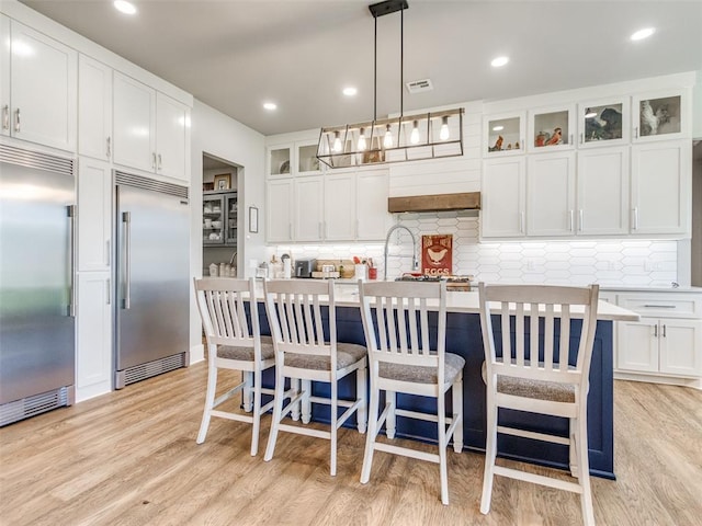 22795 Cterling Dr, Kingfisher, OK 73750 - kitchen with built in fridge, light wood finished floors, light countertops, tasteful backsplash, and recessed lighting