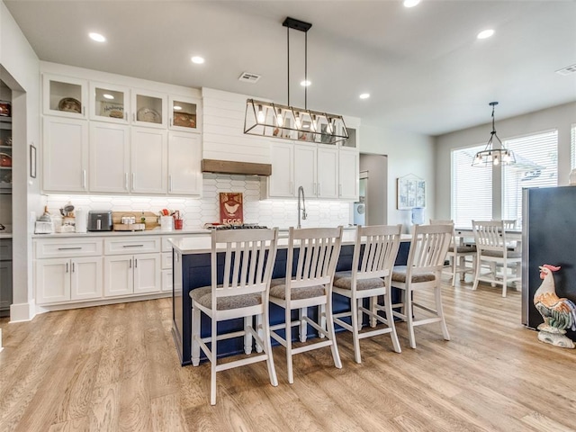 22795 Cterling Dr, Kingfisher, OK 73750 - kitchen with white cabinetry, decorative backsplash, light wood-type flooring, light countertops, and recessed lighting