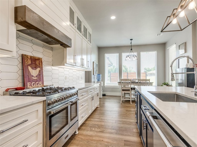 22795 Cterling Dr, Kingfisher, OK 73750 - kitchen featuring appliances with stainless steel finishes, premium range hood, white cabinetry, light stone counters, and recessed lighting