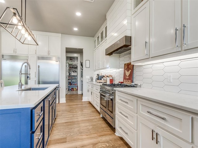 22795 Cterling Dr, Kingfisher, OK 73750 - kitchen featuring blue cabinetry, high end appliances, white cabinetry, recessed lighting, and light wood-type flooring