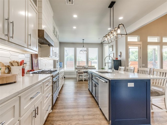 22795 Cterling Dr, Kingfisher, OK 73750 - kitchen with appliances with stainless steel finishes, a breakfast bar, recessed lighting, white cabinetry, and light wood-style floors