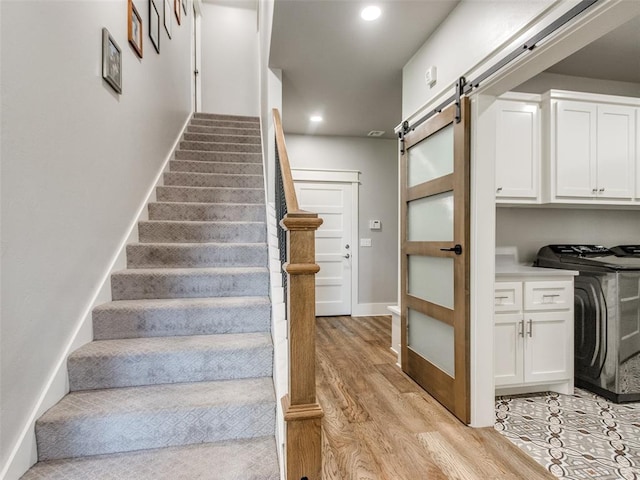 22795 Cterling Dr, Kingfisher, OK 73750 - stairs with a barn door, wood finished floors, recessed lighting, and washing machine and dryer