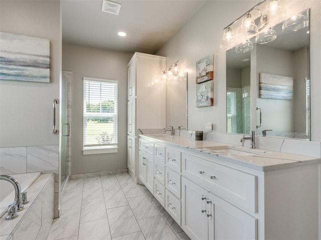 22795 Cterling Dr, Kingfisher, OK 73750 - bathroom featuring marble look tile flooring, double vanity, a shower stall, a bath, and recessed lighting