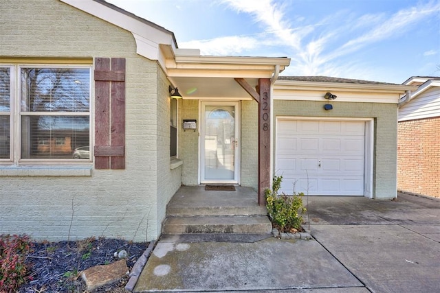 3208 NW 47th St, Oklahoma City, OK 73112 - view of exterior entry with driveway, an attached garage, and brick siding
