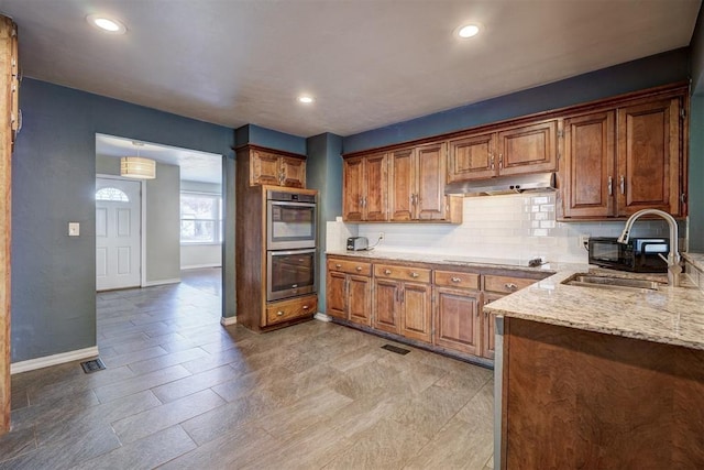 3208 NW 47th St, Oklahoma City, OK 73112 - kitchen with double oven, under cabinet range hood, brown cabinets, and recessed lighting