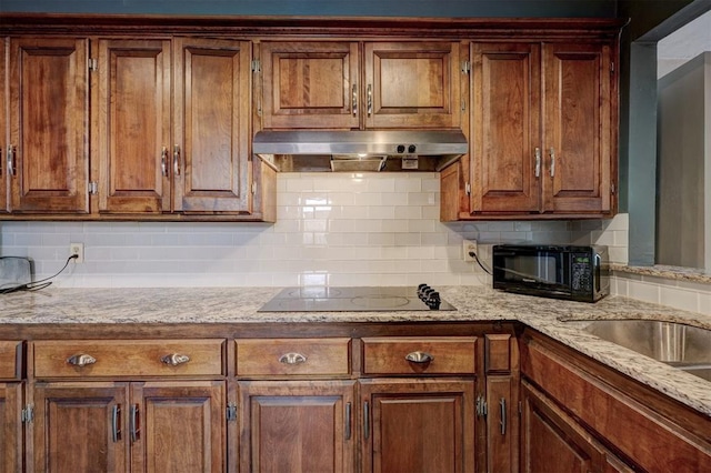 3208 NW 47th St, Oklahoma City, OK 73112 - kitchen featuring under cabinet range hood, black electric stovetop, decorative backsplash, and light stone counters