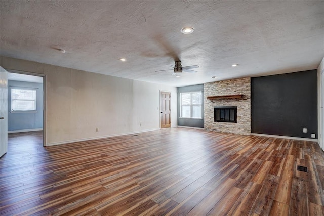 3208 NW 47th St, Oklahoma City, OK 73112 - unfurnished living room with wood finished floors, a ceiling fan, a textured ceiling, a fireplace, and recessed lighting