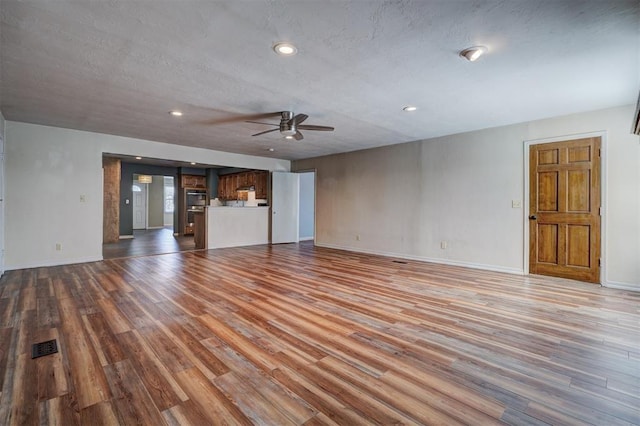 3208 NW 47th St, Oklahoma City, OK 73112 - unfurnished living room with a ceiling fan, wood finished floors, and recessed lighting