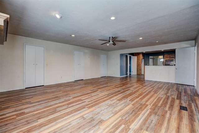 3208 NW 47th St, Oklahoma City, OK 73112 - unfurnished living room featuring a ceiling fan, light wood finished floors, and recessed lighting