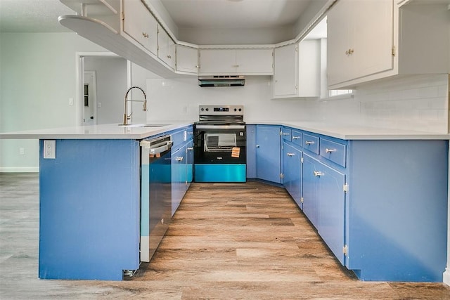 5309 S Blackwelder Ave, Oklahoma City, OK 73119 - kitchen featuring appliances with stainless steel finishes, blue cabinets, extractor fan, light wood finished floors, and a peninsula