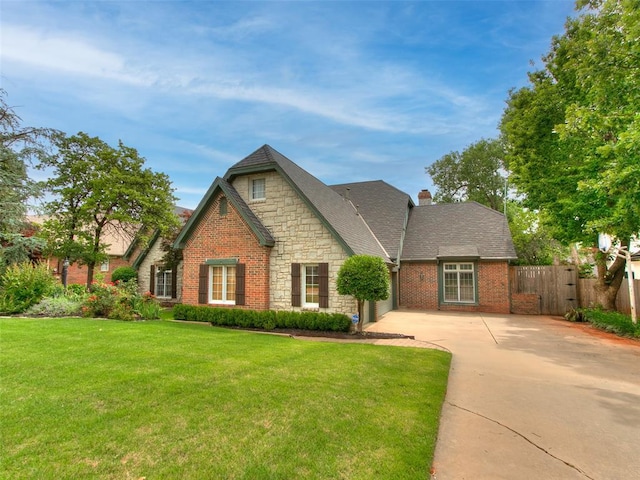 4304 Riders Mark, Edmond, OK 73025 - view of front facade with driveway, stone siding, a chimney, a garage, and brick siding