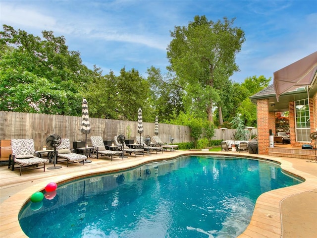 4304 Riders Mark, Edmond, OK 73025 - view of pool with a fenced backyard, a patio, a wooden deck, an outdoor hangout area, and view of wooded area