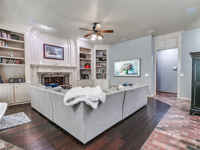 4304 Riders Mark, Edmond, OK 73025 - living area with ceiling fan, a fireplace, built in features, and dark wood-style flooring