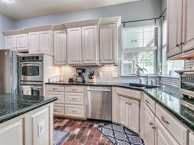 4304 Riders Mark, Edmond, OK 73025 - kitchen featuring appliances with stainless steel finishes, decorative backsplash, brick flooring, and dark stone countertops