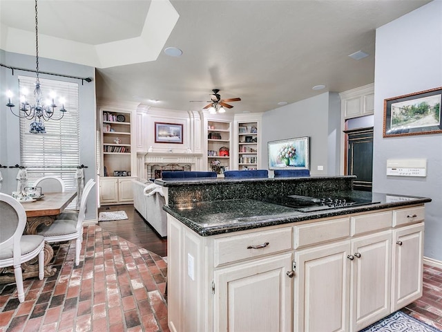 4304 Riders Mark, Edmond, OK 73025 - kitchen featuring a ceiling fan, black electric stovetop, a chandelier, brick floors, and a fireplace