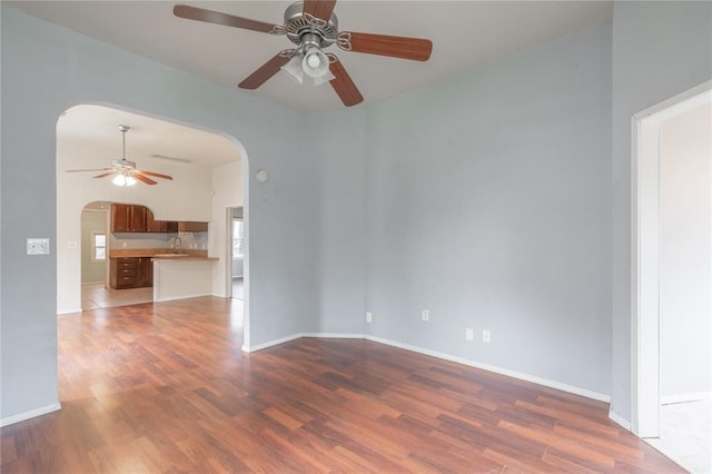 502 S 7th St, Chickasha, OK 73018 - unfurnished room with arched walkways, ceiling fan, and wood finished floors