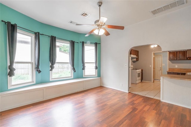 502 S 7th St, Chickasha, OK 73018 - unfurnished living room featuring arched walkways, a ceiling fan, and light wood-style flooring