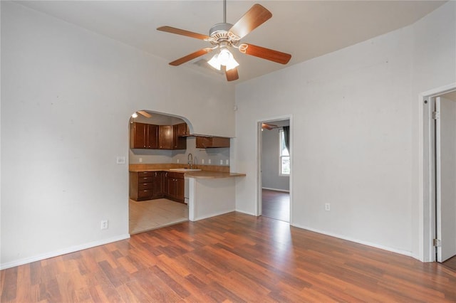 502 S 7th St, Chickasha, OK 73018 - kitchen featuring light countertops, ceiling fan, wood finished floors, and arched walkways