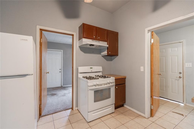502 S 7th St, Chickasha, OK 73018 - kitchen featuring white appliances, under cabinet range hood, light tile patterned floors, and brown cabinetry