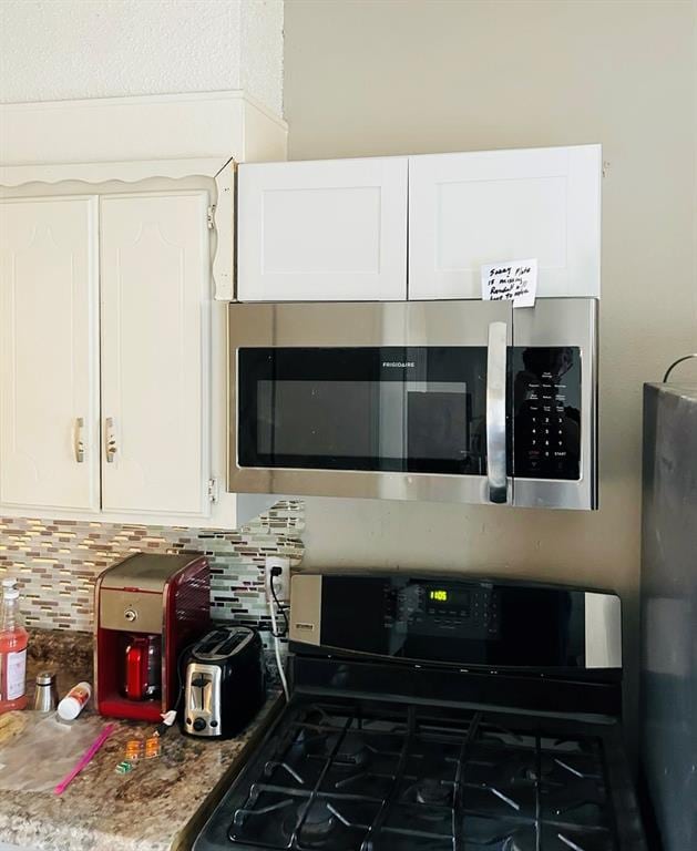 202 W Oak Ave, Seminole, OK 74868 - kitchen featuring appliances with stainless steel finishes, backsplash, and white cabinets