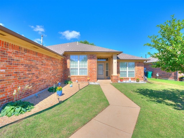 517 Firefork Ave, Yukon, OK 73099 - view of front of house featuring brick siding, a front lawn, and a shingled roof