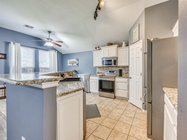 517 Firefork Ave, Yukon, OK 73099 - kitchen with stainless steel appliances, vaulted ceiling, backsplash, ceiling fan, and white cabinets