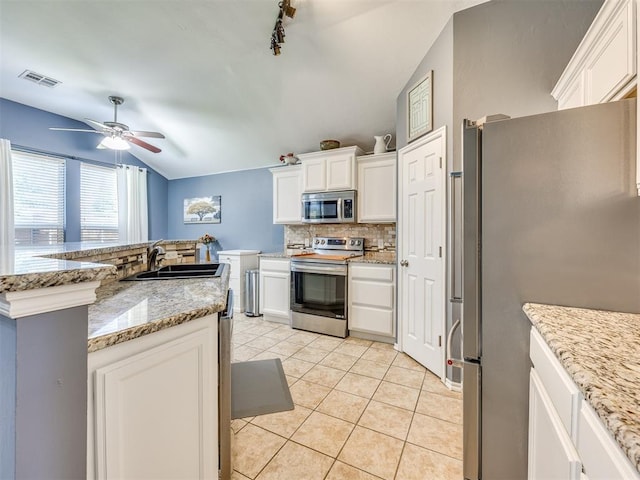 517 Firefork Ave, Yukon, OK 73099 - kitchen featuring stainless steel appliances, decorative backsplash, vaulted ceiling, rail lighting, and white cabinets