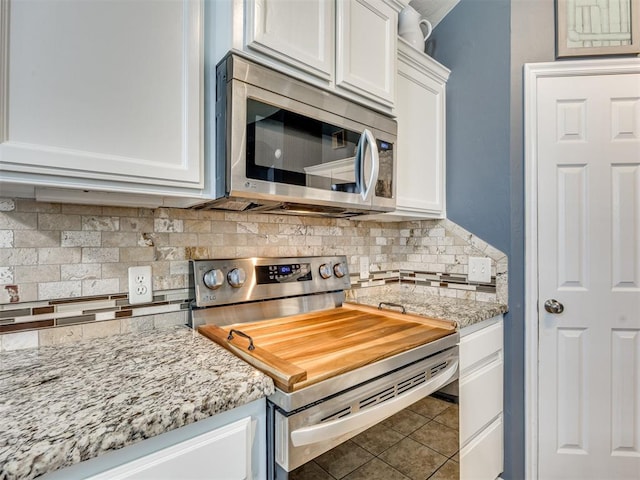517 Firefork Ave, Yukon, OK 73099 - kitchen featuring appliances with stainless steel finishes, white cabinetry, tasteful backsplash, tile patterned flooring, and light stone counters