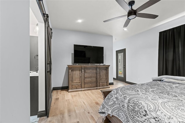 1031 Colonial Ave, Tuttle, OK 73089 - bedroom featuring a barn door, light wood-style floors, recessed lighting, ceiling fan, and ensuite bathroom