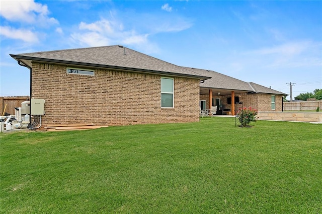 1031 Colonial Ave, Tuttle, OK 73089 - back of house featuring brick siding, a patio area, and a shingled roof