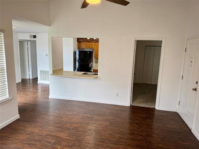 3000 Chautauqua Ave Unit 208, Norman, OK 73072 - unfurnished living room with a ceiling fan, dark wood finished floors, and a high ceiling