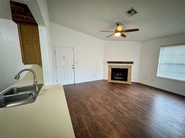 3000 Chautauqua Ave Unit 208, Norman, OK 73072 - unfurnished living room with ceiling fan, dark wood-type flooring, a brick fireplace, and vaulted ceiling