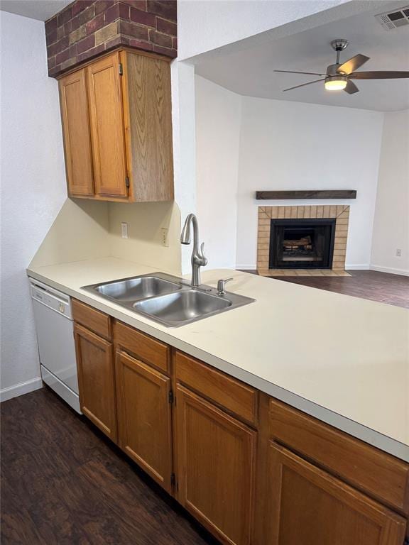 3000 Chautauqua Ave Unit 208, Norman, OK 73072 - kitchen featuring dishwasher, dark wood-style floors, light countertops, a ceiling fan, and a brick fireplace