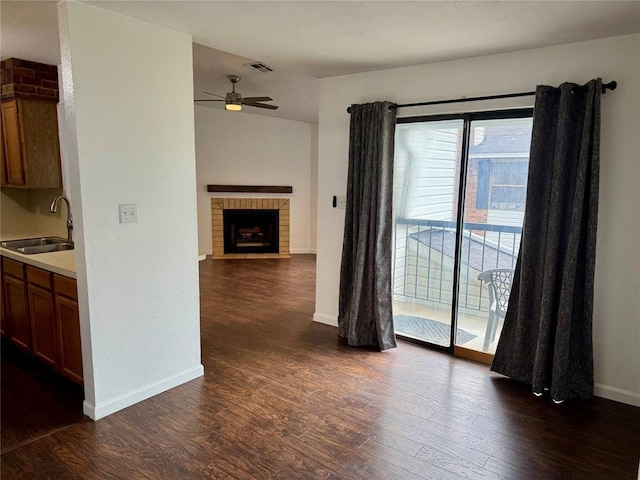 3000 Chautauqua Ave Unit 208, Norman, OK 73072 - kitchen with ceiling fan, dark wood-type flooring, light countertops, and a fireplace