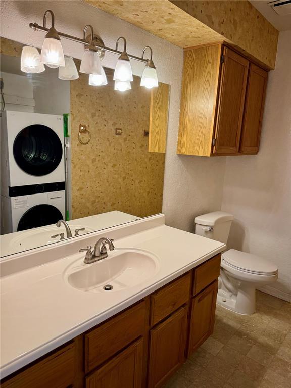 3000 Chautauqua Ave Unit 208, Norman, OK 73072 - bathroom with stacked washer and clothes dryer and vanity