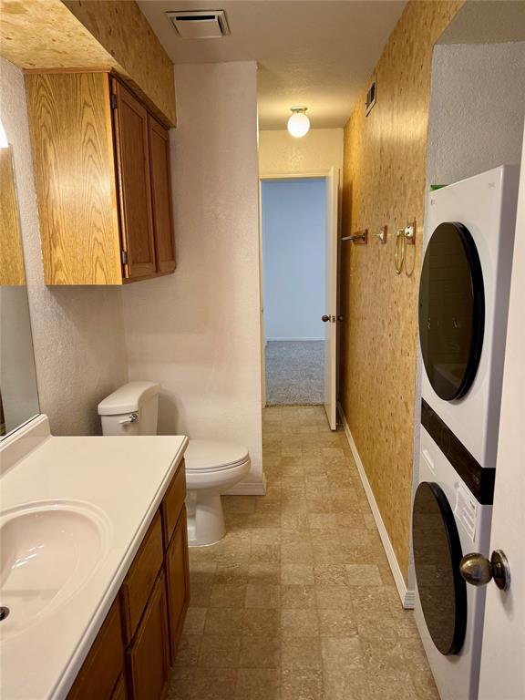 3000 Chautauqua Ave Unit 208, Norman, OK 73072 - bathroom featuring estacked washer and dryer, vanity, and tile patterned floors