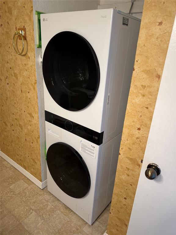 3000 Chautauqua Ave Unit 208, Norman, OK 73072 - washroom featuring stacked washing machine and dryer and baseboards
