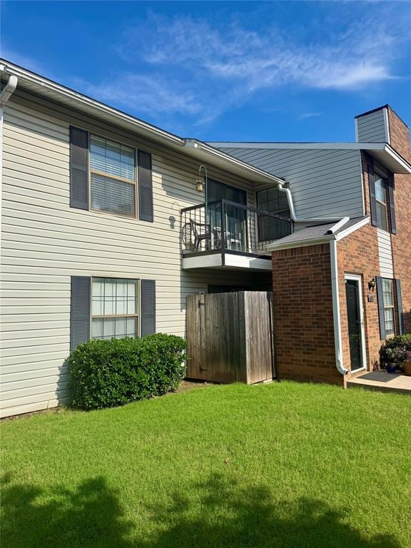 3000 Chautauqua Ave Unit 208, Norman, OK 73072 - back of property with a balcony, a lawn, and brick siding