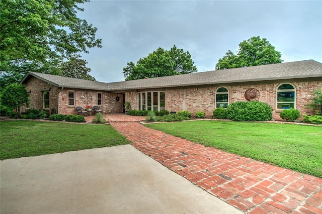 15700 N Western Ave, Edmond, OK 73013 - ranch-style house featuring brick siding, a front yard, and roof with shingles