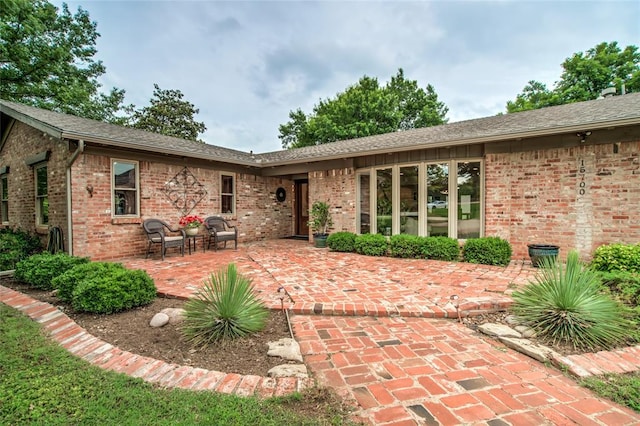 15700 N Western Ave, Edmond, OK 73013 - back of house featuring a patio area, brick siding, and roof with shingles