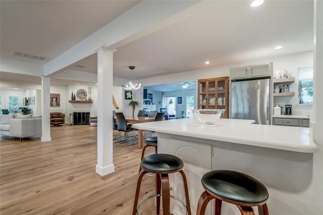 15700 N Western Ave, Edmond, OK 73013 - kitchen featuring freestanding refrigerator, open floor plan, a breakfast bar, light wood-style flooring, and recessed lighting
