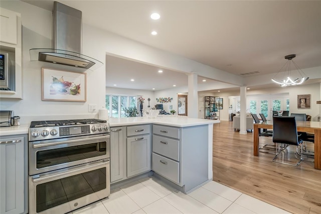 15700 N Western Ave, Edmond, OK 73013 - kitchen featuring gray cabinets, double oven range, exhaust hood, open floor plan, and a peninsula