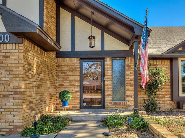 3100 N Eagle Ln, Bethany, OK 73008 - doorway to property featuring stucco siding, brick siding, covered porch, and a shingled roof