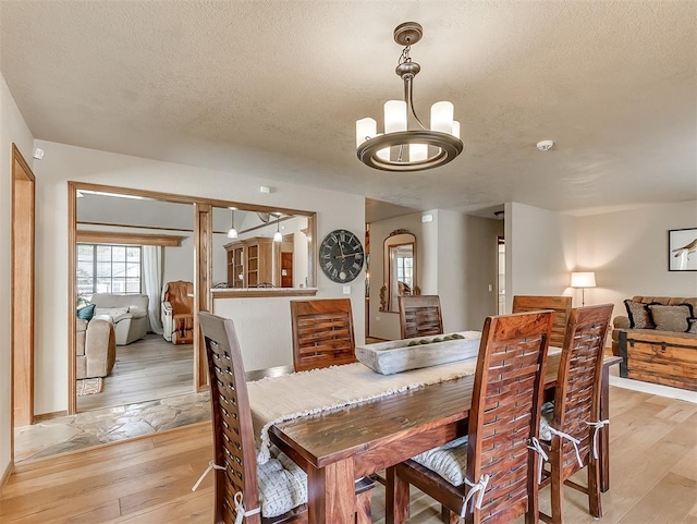 3100 N Eagle Ln, Bethany, OK 73008 - dining space with light wood-style flooring, a chandelier, and a textured ceiling