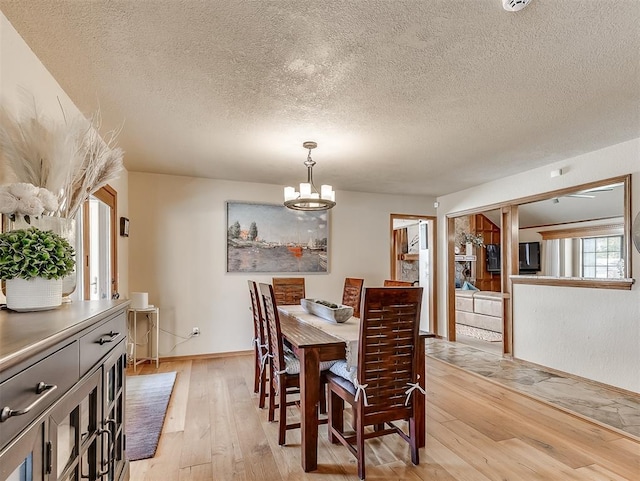 3100 N Eagle Ln, Bethany, OK 73008 - dining area featuring light wood-type flooring, a chandelier, and a textured ceiling